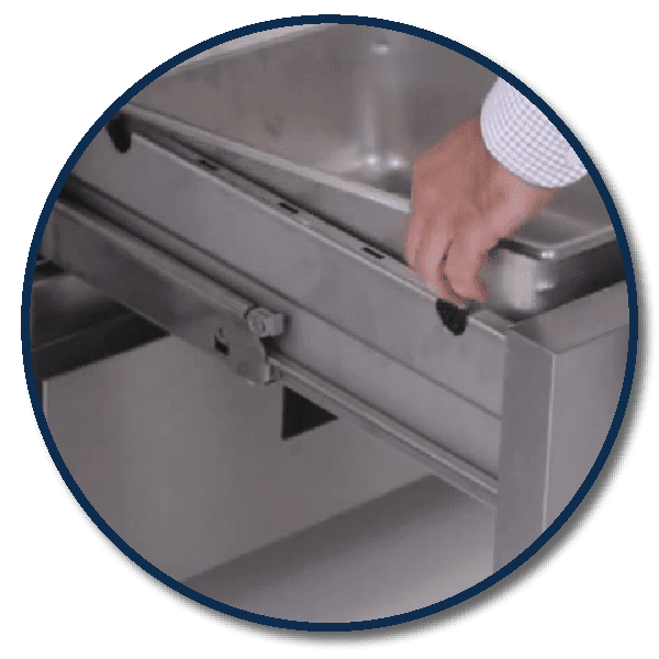 Chef removing a 6” deep food pan from a Hoshizaki Steelheart® chef base drawer, featuring easy rail cut-outs for quick access.