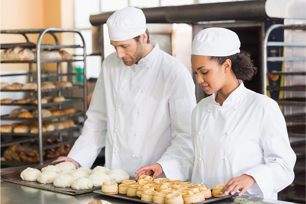 Bakers preparing pastries near Hoshizaki roll-in and roll-thru refrigerators designed for efficient bakery and foodservice operations.