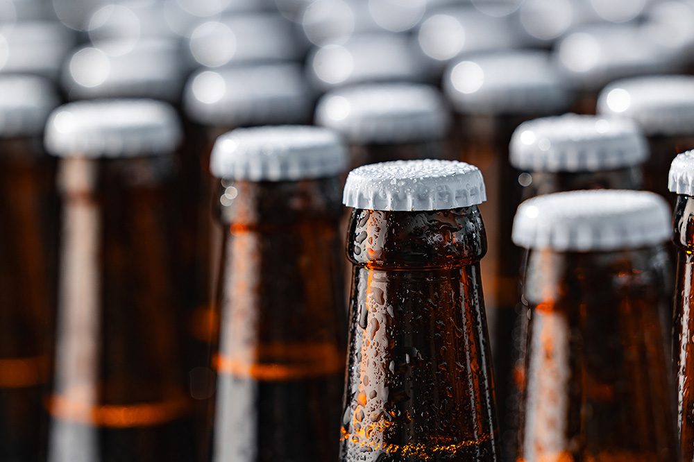 Close-up of cold beer bottles in Hoshizaki bottle cooler, highlighting condensation and sleek refrigeration performance.