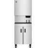 A commercial stainless steel ice maker machine with a dispenser, standing on four legs with a storage cabinet below.