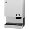 A stainless steel countertop ice and water dispenser with labeled push buttons for ice and water, and a drip tray below the dispensing area.