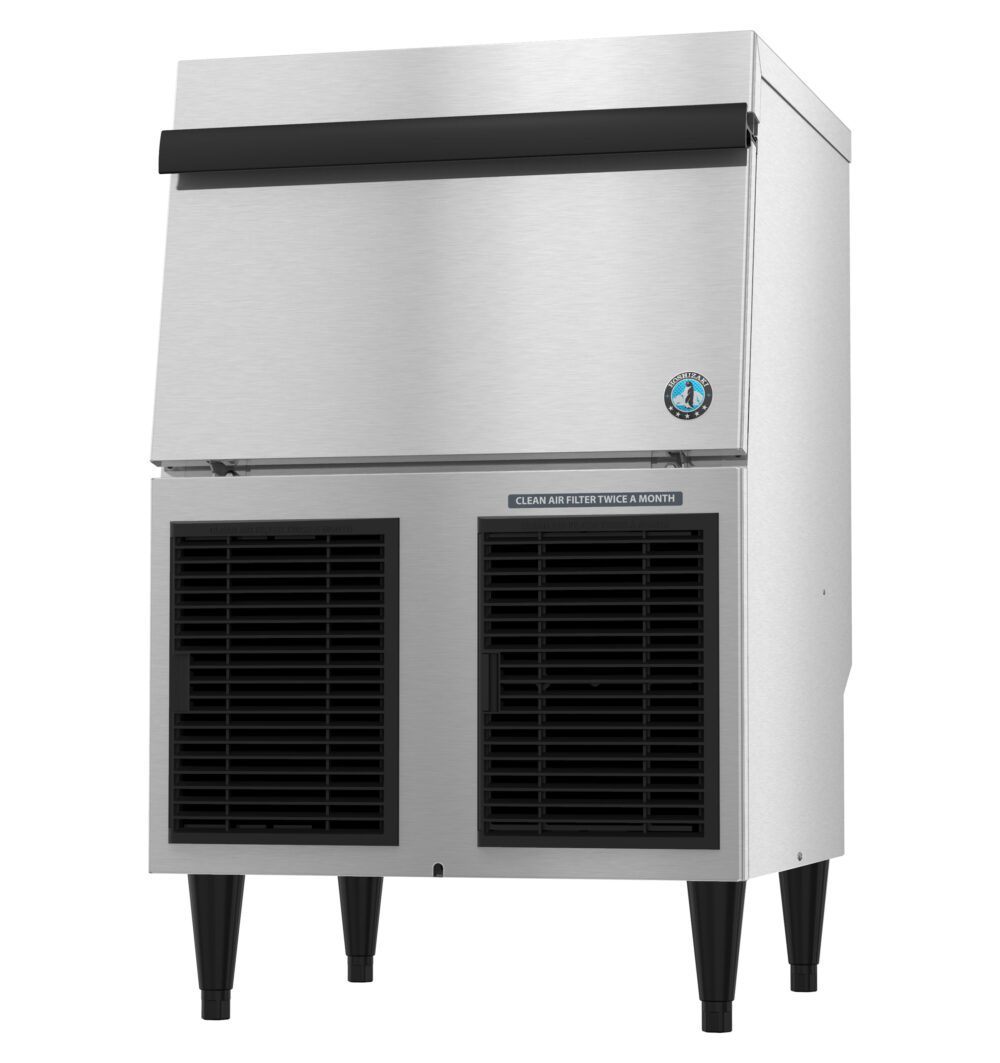 A commercial stainless steel ice maker with a top door and two black vent panels at the bottom, standing on four legs.