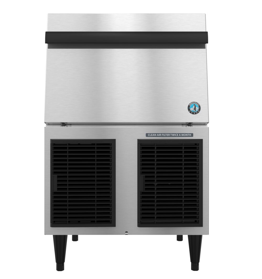 Front view of a commercial ice maker machine with a stainless steel finish, black vented panels, and a label instructing to clean the air filter twice a month.