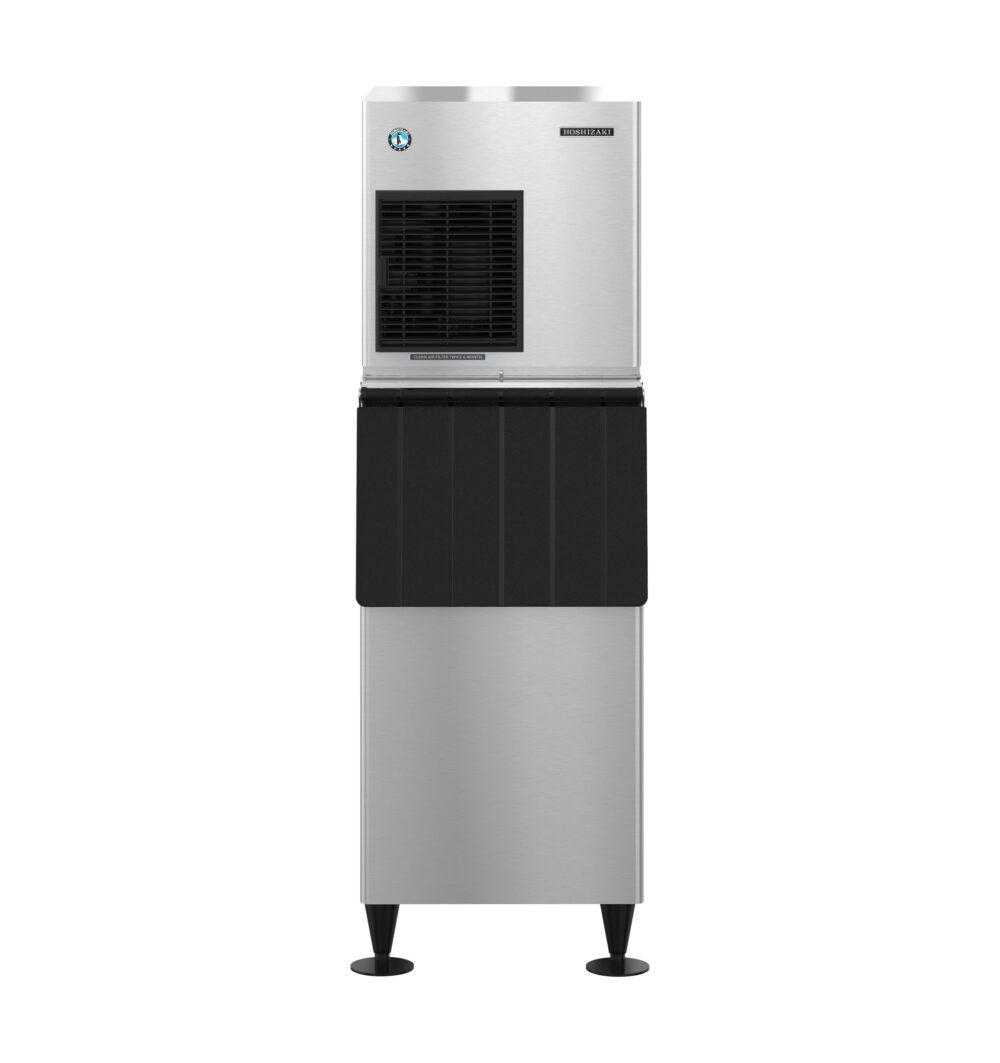 Commercial stainless steel ice machine with black vented front panel, standing on four legs, isolated on a white background.