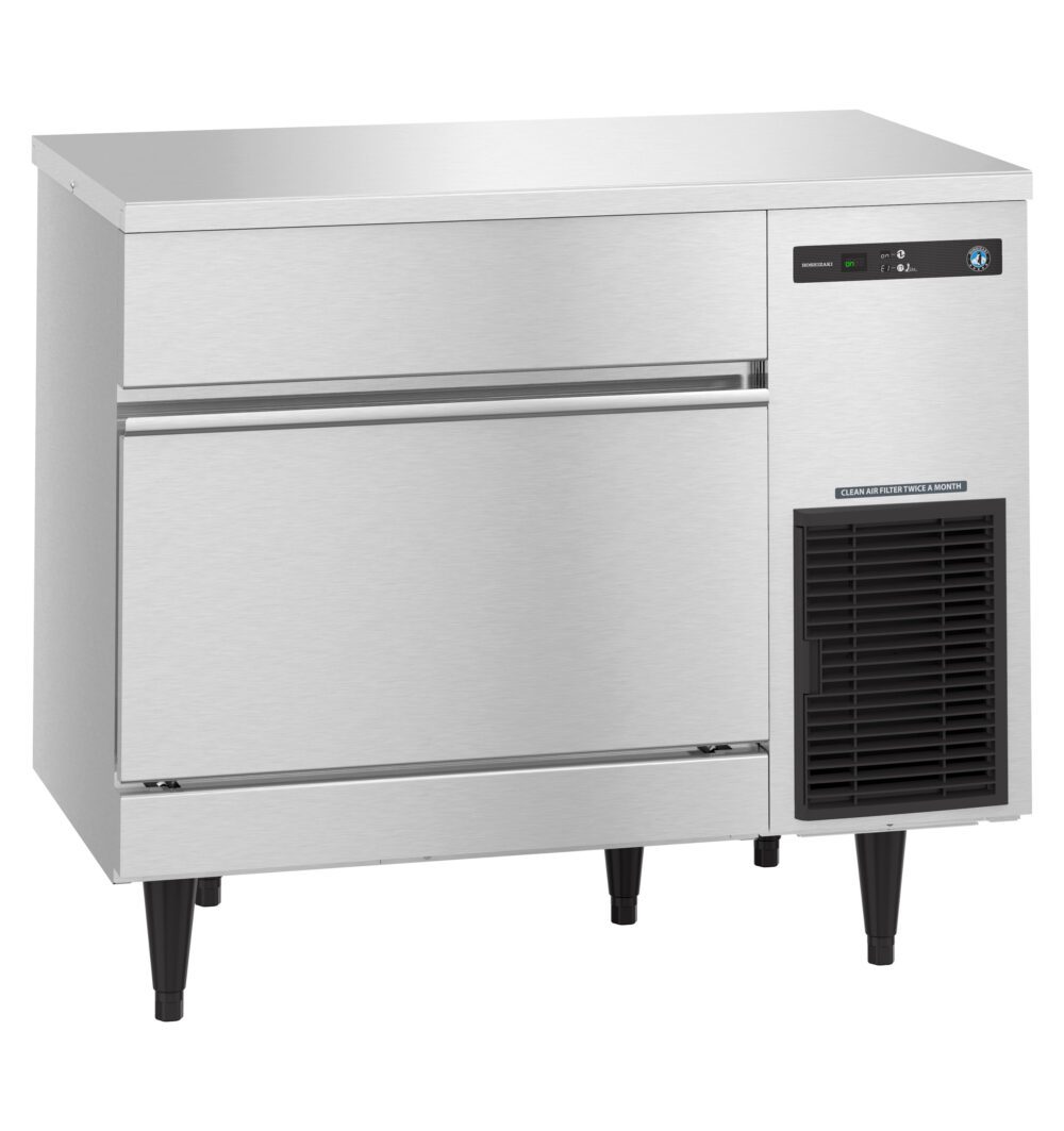Commercial stainless steel undercounter ice maker with digital display, vent, and two storage drawers, standing on four black legs.