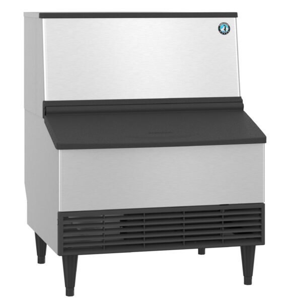 Commercial stainless steel ice machine with a black vented front panel and four legs, designed for producing and storing ice.