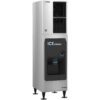 A stainless steel commercial ice dispenser with a black dispensing area and visible cup under the ice chute, standing on four legs.