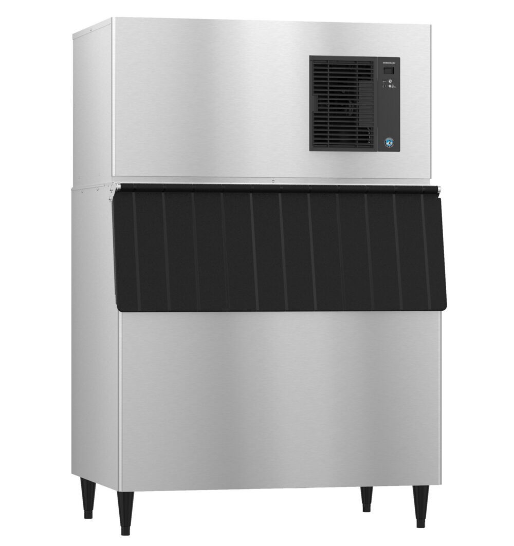 Commercial stainless steel ice machine with a black front panel and four legs, featuring a cooling vent and control panel on the upper right side.
