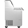 Side view of a stainless steel commercial kitchen appliance on wheels with a grated shelf and control panel, likely used for food preparation or refrigeration.