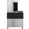 Commercial ice maker machine with a stainless steel body and black accents, featuring a top cooling unit and bottom storage bin, photographed against a plain white background.